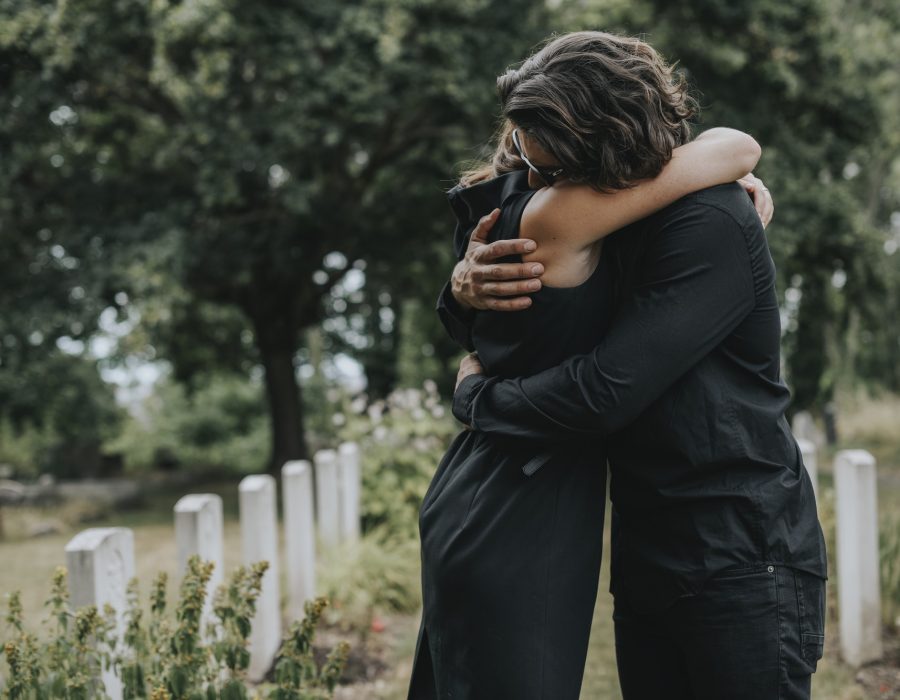 husband-trying-to-comfort-his-wife-at-a-graveyard.jpg husband-trying-to-comfort-his-wife-at-a-graveyard.jpg