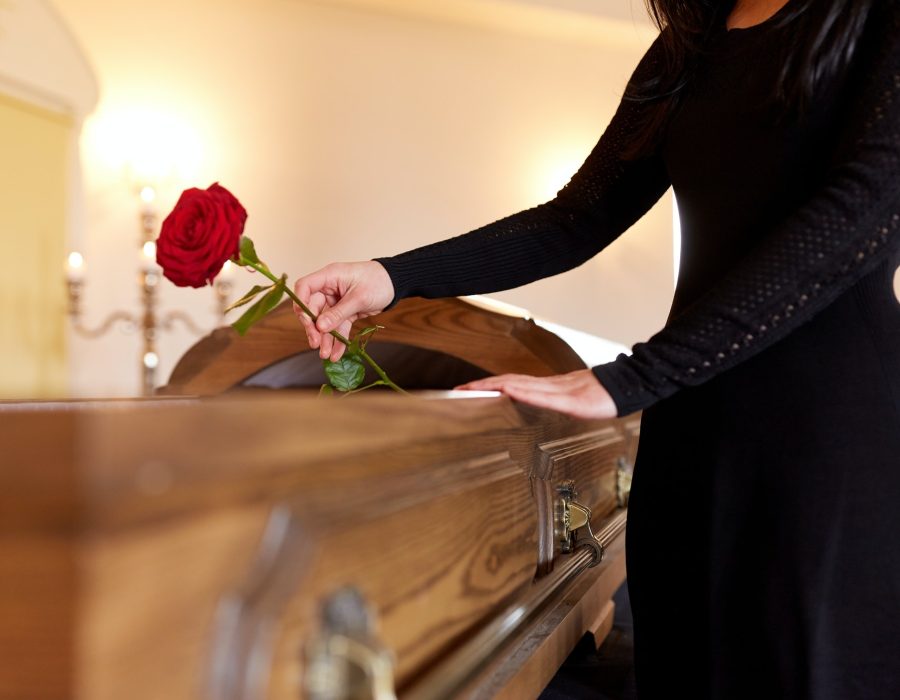 woman-with-red-roses-and-coffin-at-funeral.jpg
